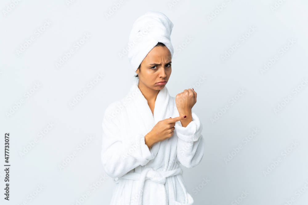 Young woman in bathrobe over isolated white background making the gesture of being late Young woman in bathrobe over isolated white background making the gesture of being late
