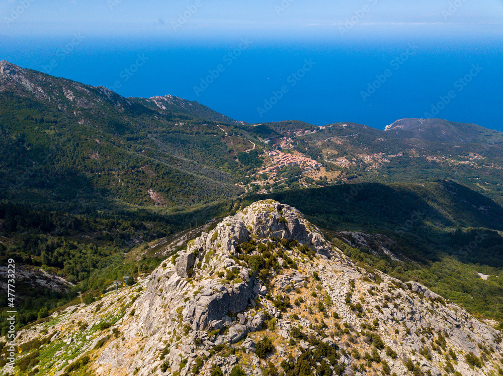 Panorama aerial drone landscape of Monte Capanne, highest moutain on Elba with green landscape and mediterranean sea in the backgroud	