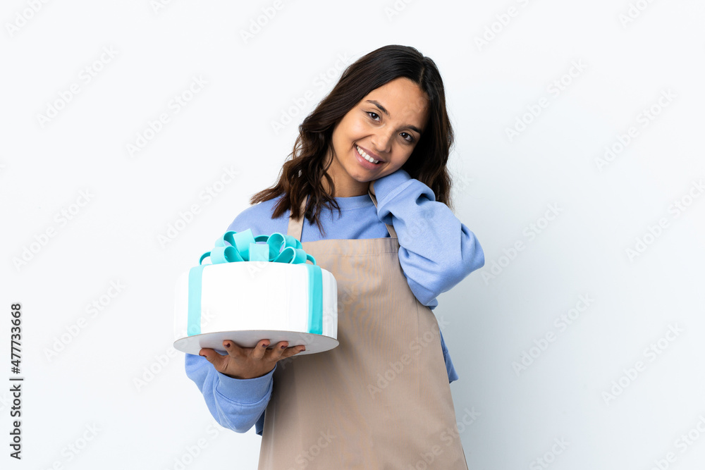 Pastry chef holding a big cake over isolated white background laughing Pastry chef holding a big cake over isolated white background laughing