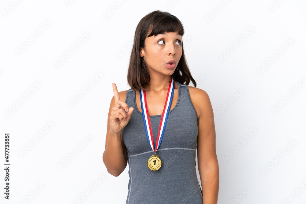 Young mixed race woman with medals isolated on white background thinking an idea pointing the finger up Young mixed race woman with medals isolated on white background thinking an idea pointing the finger up
