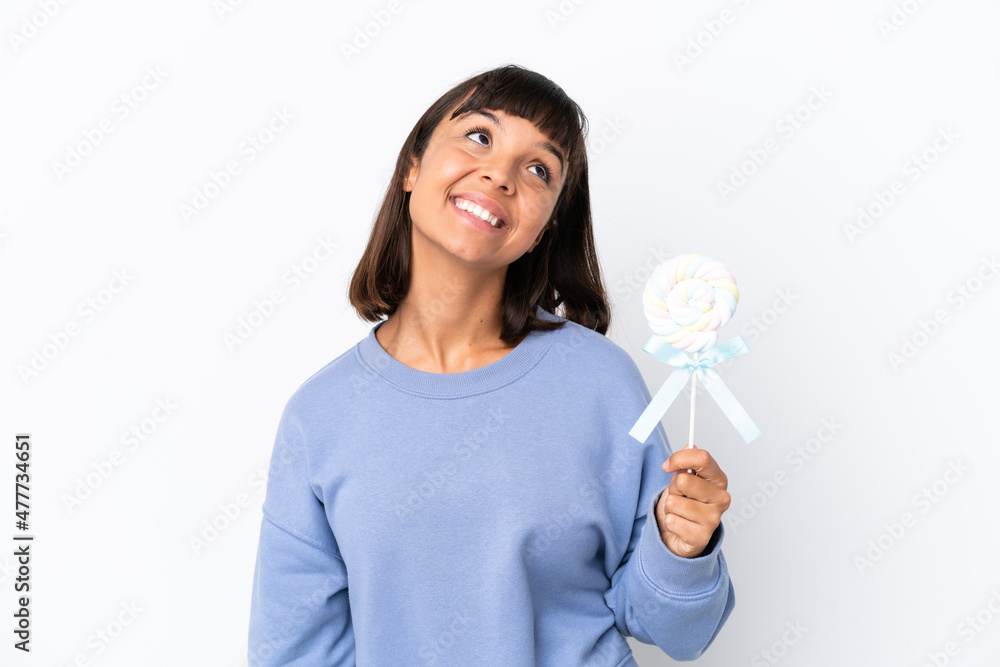 Young mixed race woman holding a lollipop isolated on white background thinking an idea while looking up Young mixed race woman holding a lollipop isolated on white background thinking an idea while looking up