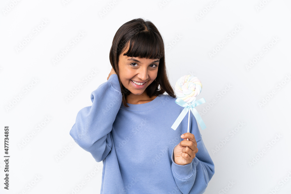Young mixed race woman holding a lollipop isolated on white background laughing Young mixed race woman holding a lollipop isolated on white background laughing