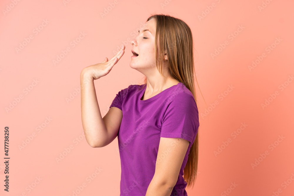Teenager Ukrainian girl isolated on pink background yawning and covering wide open mouth with hand Teenager Ukrainian girl isolated on pink background yawning and covering wide open mouth with hand