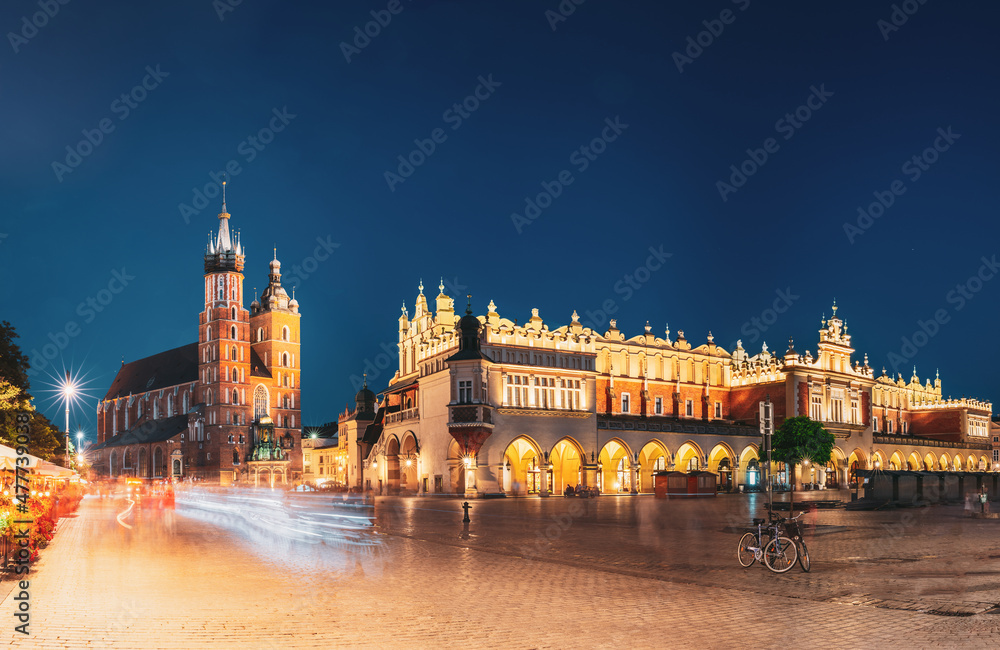 Krakow, Poland. Famous Landmarks On Old Town Square In Summer Evening. St. Mary's Basilica, Cloth Hall Building In Night Lighting. UNESCO World Heritage Site