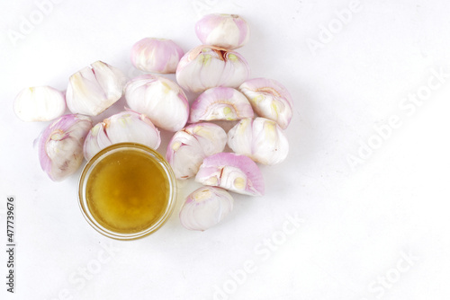 red inion oil in a container on table on white background  photo