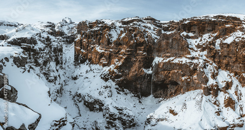 Secret canyon named Mulagljufur canyon in South Iceland. Waterfall below mountain top in winter and snow landscape. Top tourism destination. South East of Iceland, Europe photo