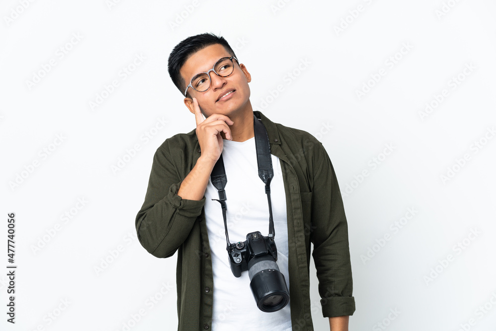 Fototapeta premium Young Ecuadorian photographer isolated on white background thinking an idea while looking up