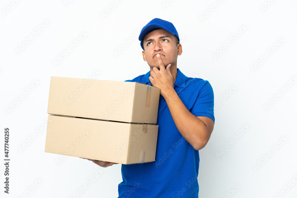 Delivery Ecuadorian man isolated on white background having doubts while looking up Delivery Ecuadorian man isolated on white background having doubts while looking up