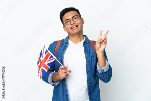 Young Ecuadorian woman holding an United Kingdom flag isolated on white background smiling and showing victory sign