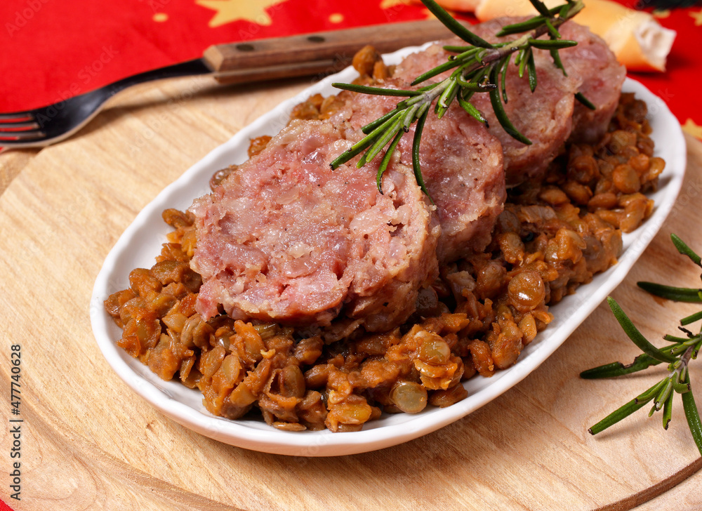Sliced cotechino salami with a side dish of stewed lentils. Sliced cotechino salami with a side dish of stewed lentils.