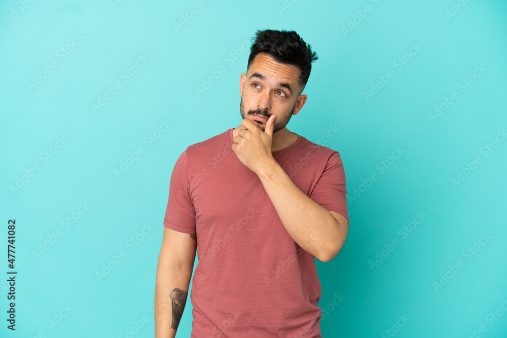 Young caucasian man isolated on blue background having doubts and with confuse face expression Young caucasian man isolated on blue background having doubts and with confuse face expression