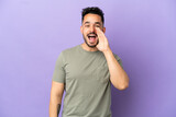 Young caucasian man isolated on purple background shouting with mouth wide open