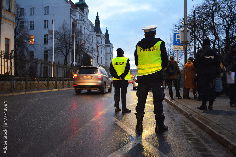 Policjanci ruchu drogowego polskiej policji w mieście podczas kontroli ruchu pojazdów.  - obrazy, fototapety, plakaty 