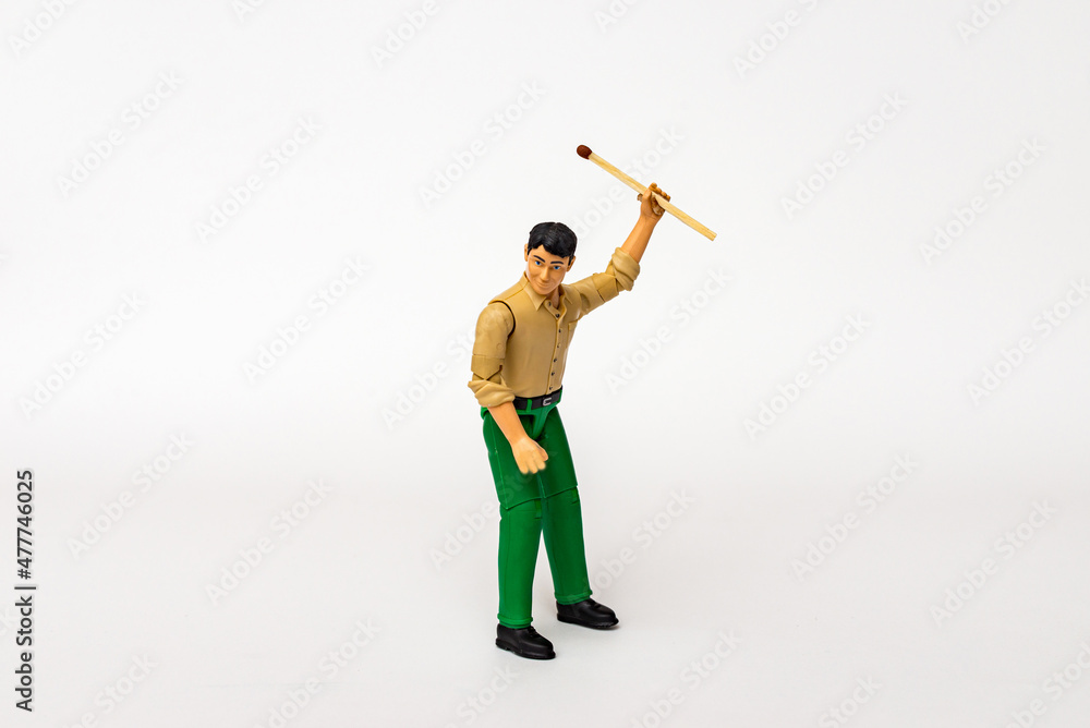 Miniature toy businessman figure holding mach stick, on white gray background. Miniature toy businessman figure holding mach stick, on white gray background.