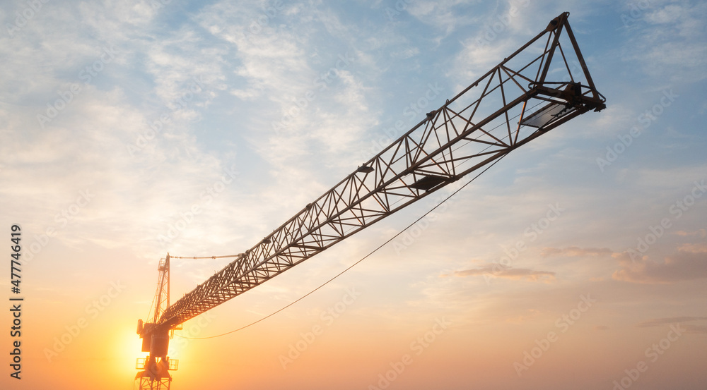 Construction cranes at dawn in the morning mist.