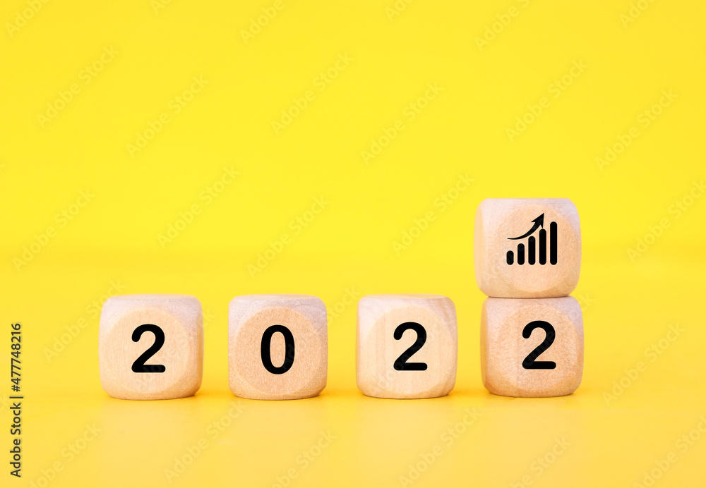 Wooden cube with 2022 text, concept to success of growing business. Wooden cube with 2022 text, concept to success of growing business.