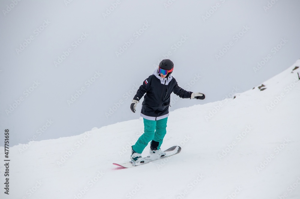 a girl on a snowboard rides down the side of the mountain