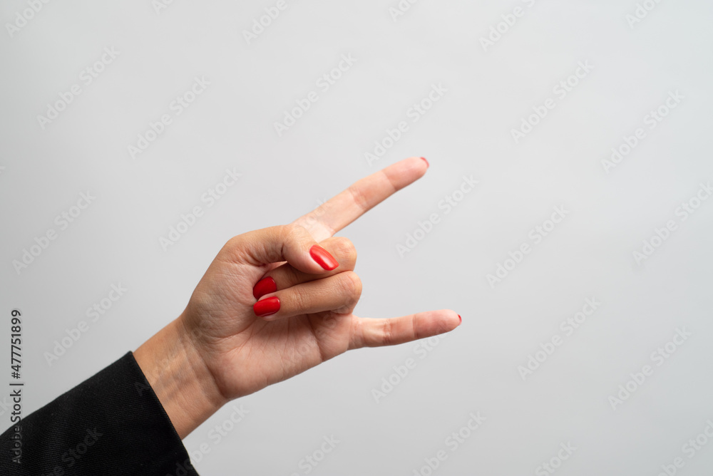 Female hand with red manicure shows gesture on white background Female hand with red manicure shows gesture on white background