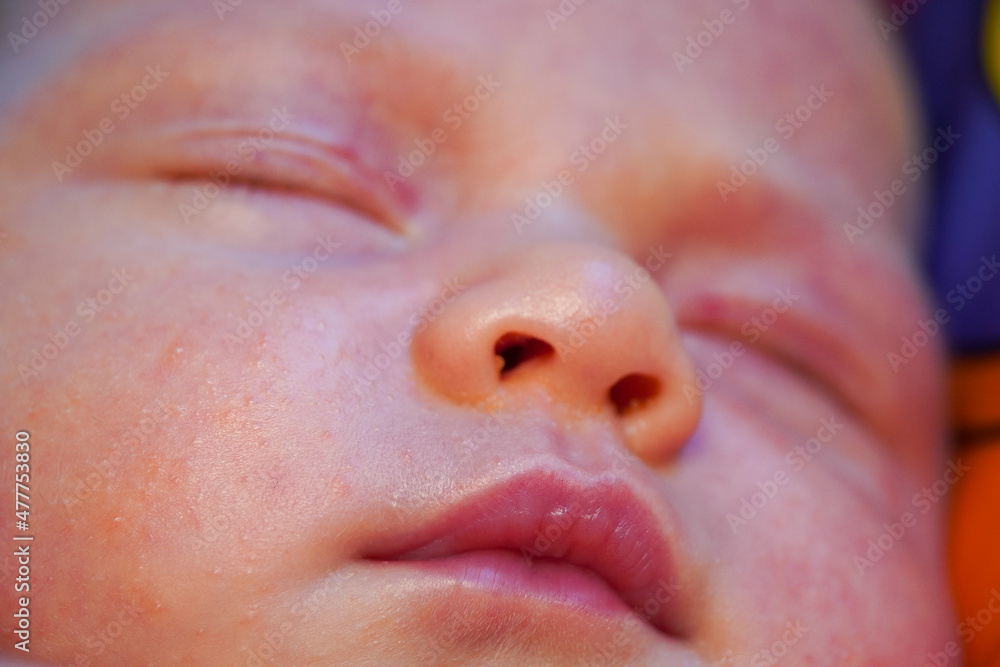 Fototapeta premium the face of a sleeping newborn caucasian baby. Focus to mouth lips. High quality photo. close up view macro closeup
