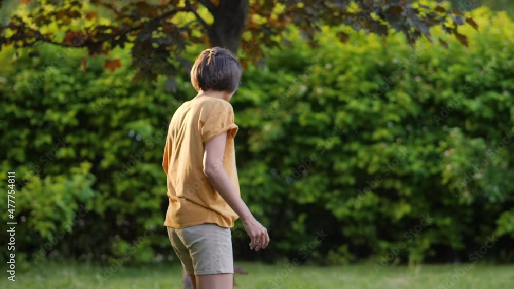 Woman plays frisbee on grass lawn. Summer vibes. Outdoor leisure activity. Family life. Sports game at backyard. Woman plays frisbee on grass lawn. Summer vibes. Outdoor leisure activity. Family life. Sports game at backyard.