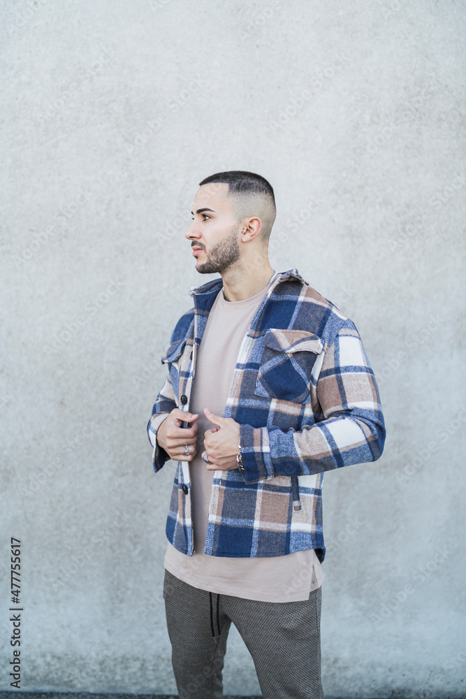 Chico joven tatuado con ropa urbana moderna posando en la calle Chico joven tatuado con ropa urbana moderna posando en la calle