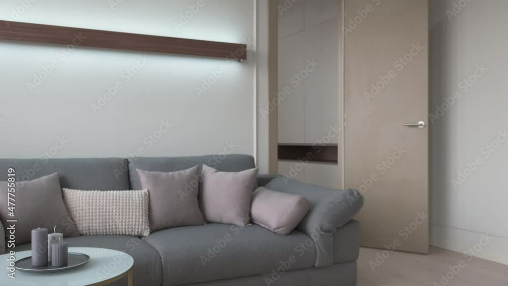 Scandinavian style interior with a large grey sofa a man comes out of the room Scandinavian style interior with a large grey sofa a man comes out of the room