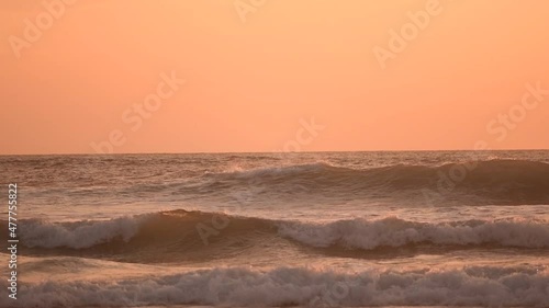 Surfer in the wave at the sunset in slow-motion