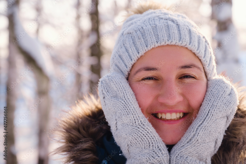 Happy Asian woman walking in winter snow forest. Cold weather hat and warm coat. idea and concept of healthy active lifestyle and good mood in any weather