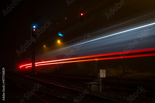 Feu vert de nuit dans le brouillard, avec la trace lumineuse du train qui passait.