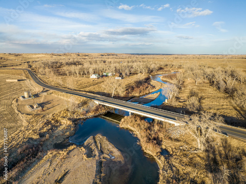 aerial view of northern Colorado landscape in fall or winter scenery - St Vrain Creek, highway with a bridge, farmland, and oil extraction