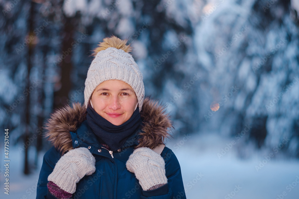Happy Asian woman walking in winter snow forest. Cold weather hat and warm coat. idea and concept of healthy active lifestyle and good mood in any weather Happy Asian woman walking in winter snow forest. Cold weather hat and warm coat. idea and concept of healthy active lifestyle and good mood in any weather