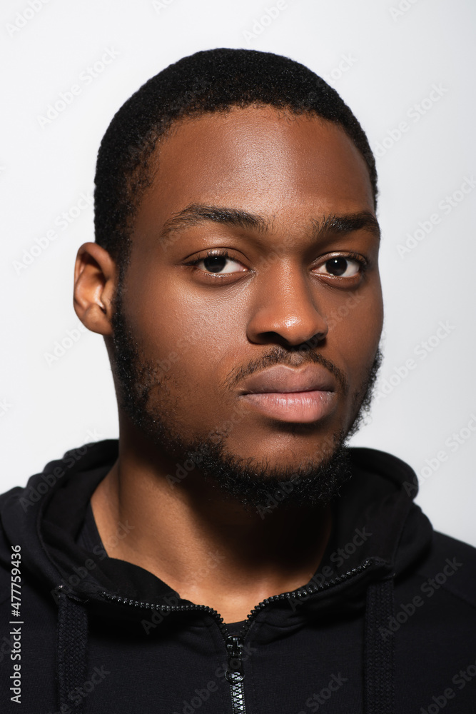 Obraz premium african american man in hoodie looking at camera isolated on grey.