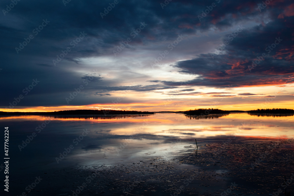 Dramatic sky and sunrise over the water this tranquil winter morning by the lake. Photo taken in Västerås, Sweden.