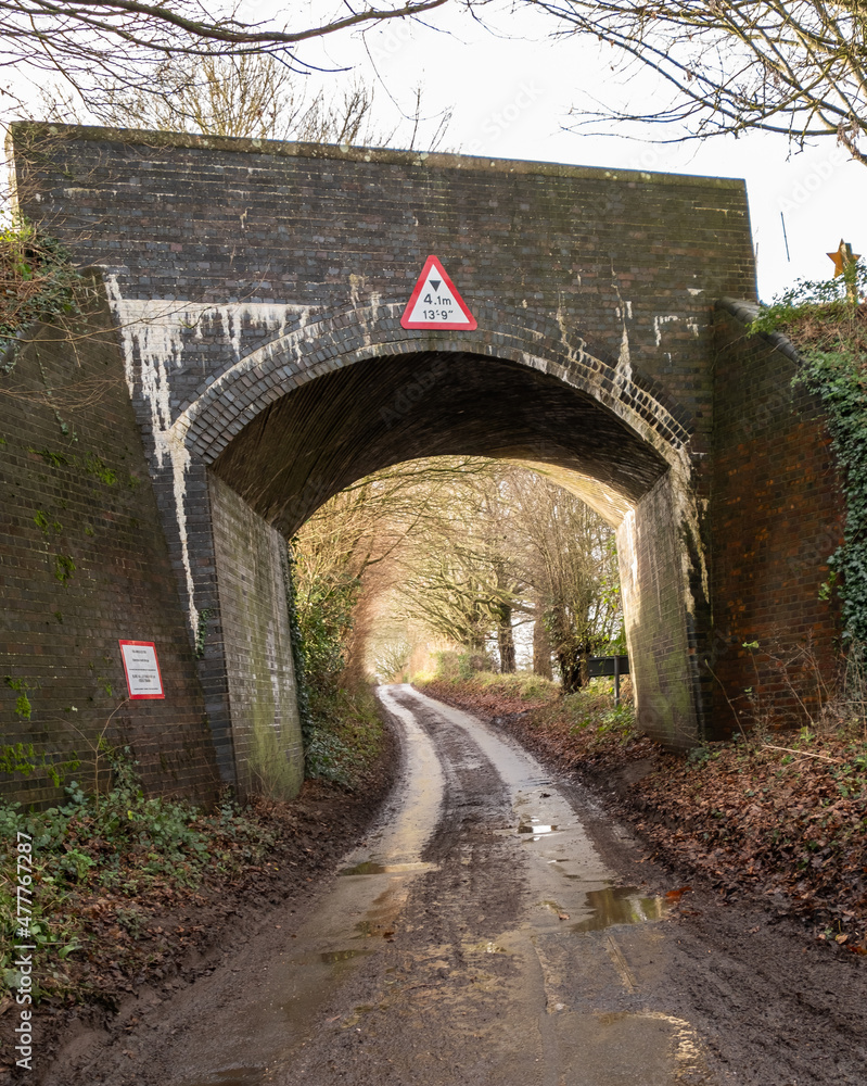 Obraz premium One of the many Bure Valley railway bridges over a rural road in the village of Brampton, Norfolk. With a 4.1m height restriction this bridge is not suitable for high vehicles.