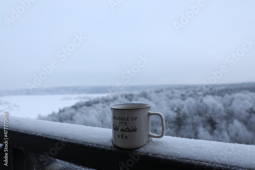 Fotografie, Obraz Cup with coffee or tea on the balcony against the background of the winter fores