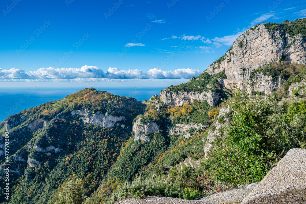 View along the Amalfi Coast of Italy from the Sentiero degli Dei, aka Path of the Gods, during December with autumn leaf color, white limestone cliffs and the turquoise blue Tyrrhenian Sea