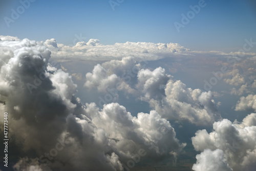 Fotografía Aerial view from airplane window of white puffy clouds on bright sunny day