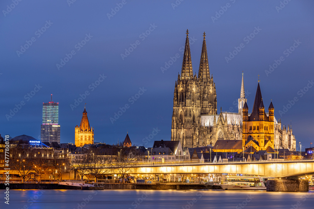 Fototapeta premium Illuminated historical buildings against Cologne winter skyline