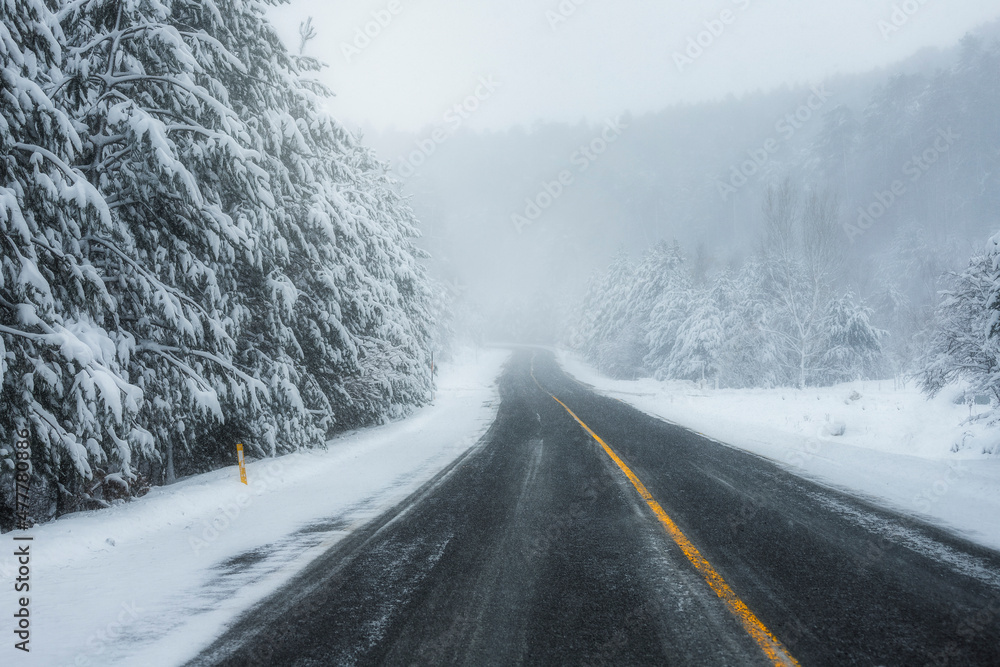 Snowy and frozen mountain road in winter landscape