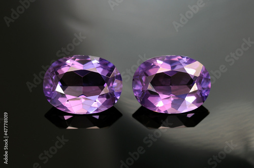 USSR era lab created synthetic alexandrite gemstones pair. Purple color, oval faceted, transparent common vintage gems removed from used earrings made in Russia. Mass market man made stones. Rare now. photo