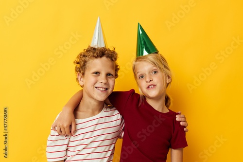 Boy and girl smiling and posing in casual clothes against on colored background
