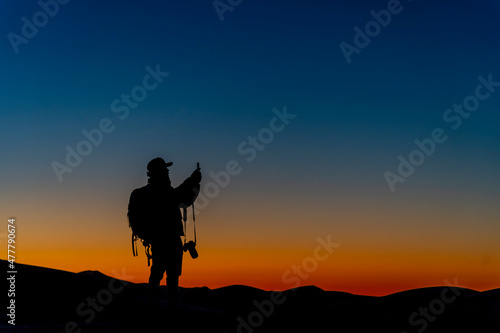 A Lone Photographer Is Silhouetted Against The Sky As The Sun Rises On The Sahara Desert In Morocco, Arica