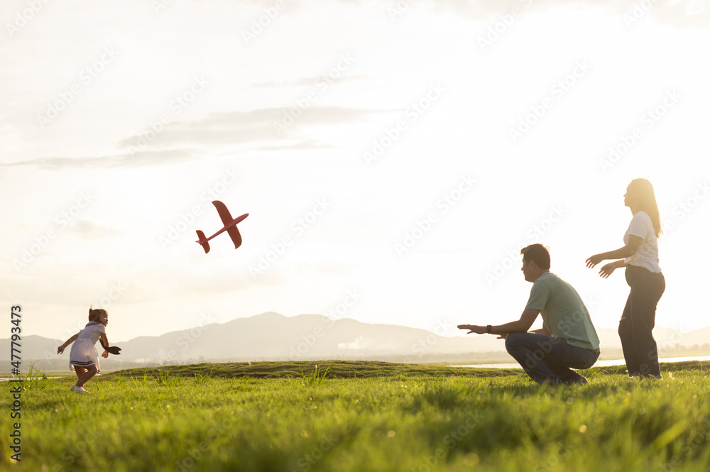 Asian children playing cardboard airplane together in the park outdoors Asian children playing cardboard airplane together in the park outdoors