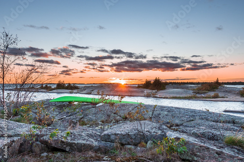 Sunset seen  on a rocky campsite on Georgian Bay  Ontario Canada with a green kayak in the foreground.