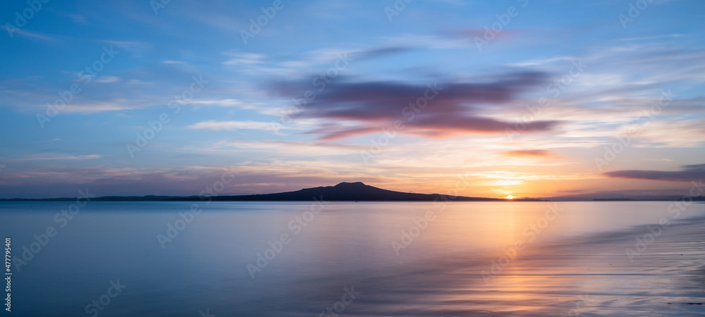 Fototapeta premium Sun rising over the Rangitoto Island at Milford Beach, Auckland.