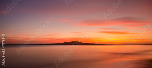 Milford Beach at dawn with Rangitoto Island in the distance, Auckland. © Janice