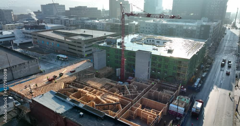 Construction crane for new building infrastructure. Growth in urban downtown American city. Aerial drone reveal shot. Construction crane for new building infrastructure. Growth in urban downtown American city. Aerial drone reveal shot.