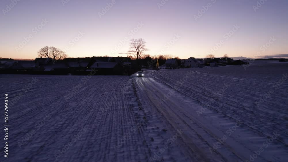 Drone View of Car Driving on Icy Road in Danish Winter Countryside - Dolly Shot Drone View of Car Driving on Icy Road in Danish Winter Countryside - Dolly Shot