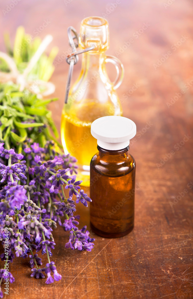 Fresh lavender bottles of aromatic oil over wooden background. Summer floral background with lavender flowers Fresh lavender bottles of aromatic oil over wooden background. Summer floral background with lavender flowers