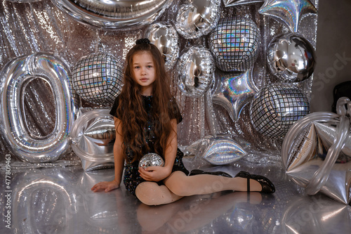 cute little child girl in black dress on confetti background